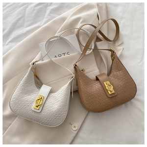 Detail of woven texture straw crescent bags with gold hardware and shoulder straps