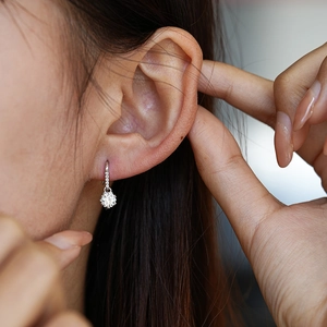 Elegant S925 sterling silver snowflake moissanite stud earrings on a female ear model