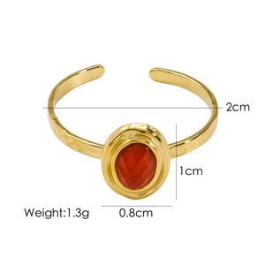 Detailed view of gold stainless steel open ring with red faceted gemstone and dimensions