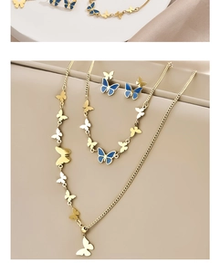 Detail of gold butterfly jewelry set with necklaces and earrings in blue enamel
