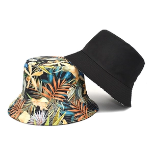 Double-sided reversible bucket hat featuring tropical palm leaf print and solid black finish