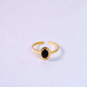 Close-up of gold open ring featuring a polished oval black natural stone inlay