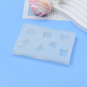 DIY silicone mold for resin gingerbread man and Christmas tree charms on blue background