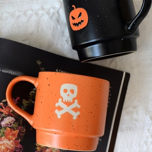 Halloween ceramic mug set with matte finish featuring pumpkin and skull design patterns