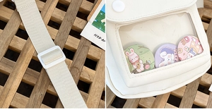 Detail of adjustable strap and clear PVC window on a beige canvas kawaii crossbody bag