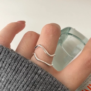 Minimalist double-layered wavy sterling silver open ring shown on finger with clean background