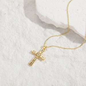 Detailed close-up of a 14K gold plated cross pendant with clear cubic zirconia stones