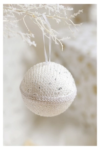Macro view of white knitted Christmas ball with lace trim and silver sequins detail