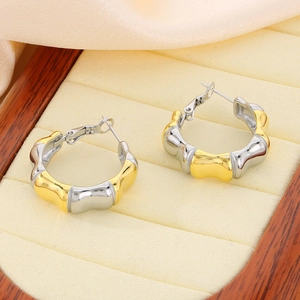 Detail of two-tone bamboo style hoops in gold and silver finish on a luxury display