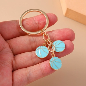 Golden alloy keychain with three light blue basketball charms for sports enthusiasts