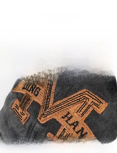 Macro shot of detailed orange embroidery on dark grey washed cotton baseball cap