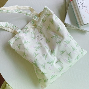 Detailed top view of a floral cotton tote bag with leaf patterns and a fabric label