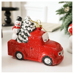 Detail view of red Christmas train ornament with a green tree and faux snow texture