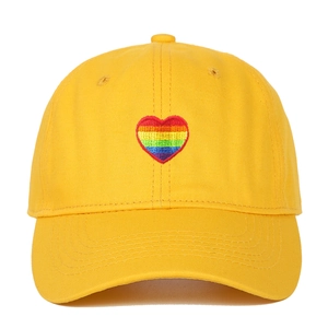 Close-up of rainbow heart embroidery on yellow cotton twill baseball cap fabric
