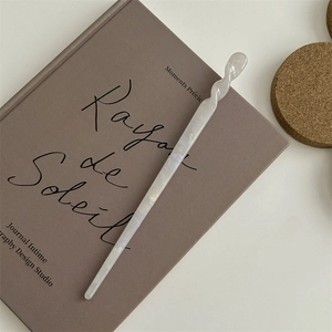 Dettaglio di un fermaglio per capelli bianco perlato su sfondo di un libro vintage