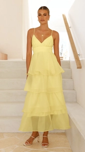 Detail of layered yellow chiffon tiered dress with elegant backless straps for formal events