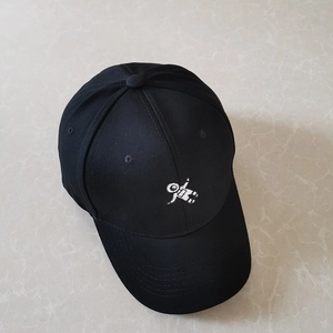 Close-up of a black cotton baseball cap featuring a white astronaut embroidery detail