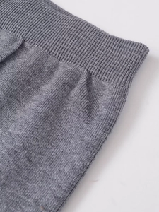 Détail de la texture en maille grise et des finitions côtelées du pantalon large