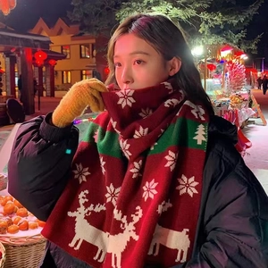 Red Christmas knit scarf with white reindeer and snowflake patterns worn by model