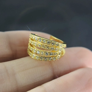 Macro shot of gold-plated non-pierced ear cuff with four rows of sparkling zircons