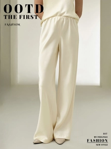 Detail view of cream white satin wide-leg trousers with elegant glossy fabric texture