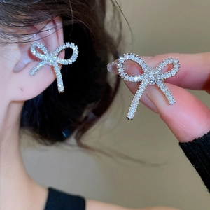 Close-up of sparkling bow-shaped silver earrings with micro-pave cubic zirconia details