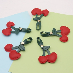 Detailed view of red PU leather cherry cord organizers with green leaves and metal snaps