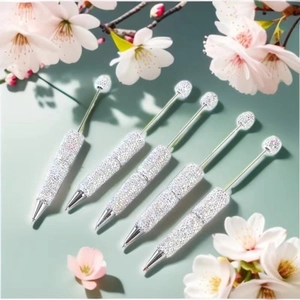 Detailed view of silver beaded pens with full rhinestones and cherry blossom accents