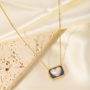 Gold-plated heart necklace with blue enamel and white shell inlay on marble background