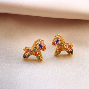Gold-plated rainbow zircon pony stud earrings with multi-colored stones on yellow silk