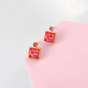 Detail of square pink crystal earrings with faceted stone in a gold setting
