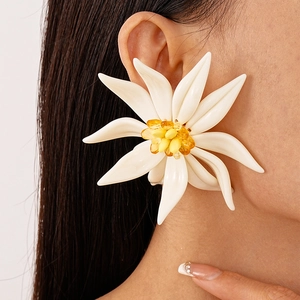 Macro detail of oversized resin flower earring with white petals and amber crystal core