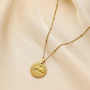 Detail shot of a golden zodiac coin pendant with horse relief and sunburst texture