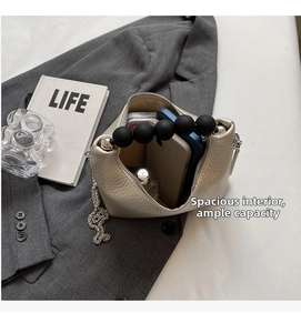 Macro shot of the open beige leather mini bag showing storage space for phone and perfume