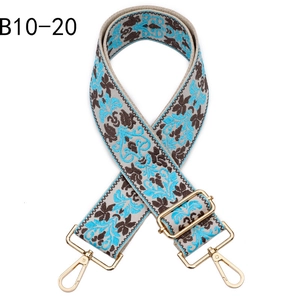 Detail of bohemian jacquard bag strap with blue floral pattern and gold metal hooks