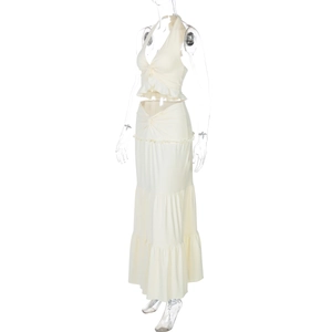 Detail of white halter neck top with knot front and ruffled tiered maxi skirt set