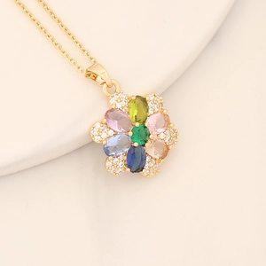 Detailed view of copper flower pendant with colorful cubic zirconia and a green center stone
