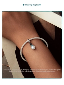 Detailed view of an S925 silver snowman charm with pearl on a woven bracelet
