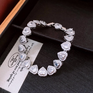 Detail of heart-shaped zircon tennis bracelet with halo setting on black jewelry box
