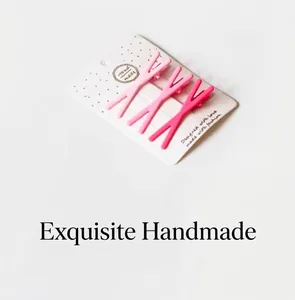 Close-up of three pink matte metal hair clips with V-shape design on a display card