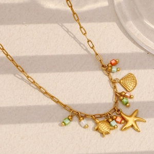 Détail d'une chaîne trombone plaquée or 18 carats avec breloques étoile de mer et tortue