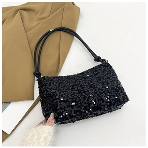 Detailed top view of black sequin baguette bag with adjustable strap on neutral background