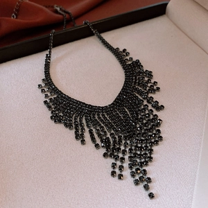 Detail of elegant black rhinestone fringe necklace on a white jewelry display tray