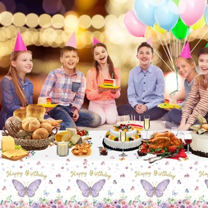 Children celebrating birthday with floral Happy Birthday tablecloth and party balloons