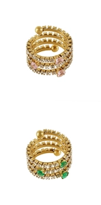 Detail of layered gold spiral rings with pavé crystals and heart-shaped gemstones