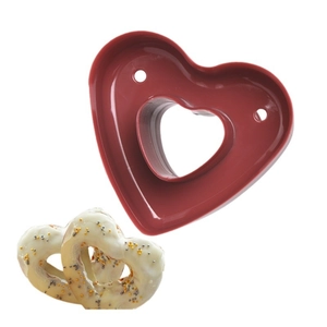 Dark red plastic heart-shaped donut mold for baking cookies and cakes on white background