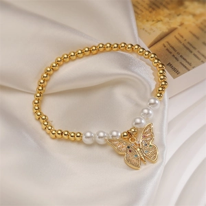 Close-up of butterfly bracelet with gold beads, white pearls and colorful zircons