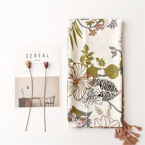 Flat lay of a tropical floral silk scarf with tassels and aesthetic cereal magazine