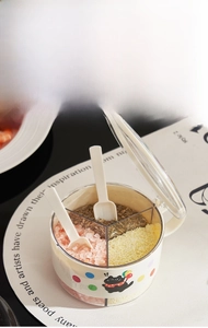 Close-up of three-compartment seasoning box with spoons and cat pattern lid