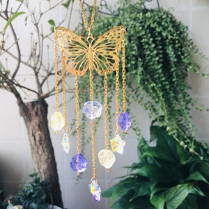 Detail of butterfly suncatcher with golden filigree and multi-colored crystal prisms